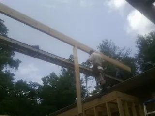 Carpenter setting a ridge beam over a new addition frame — Ice Dam Removal by Roofing Brothers in Pilot Mountain