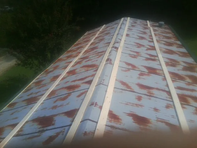 Rusted metal roof panels with new wood purlins before replacement — Storm Damage Roof Repair in Pilot Mountain by Roofing Brothers