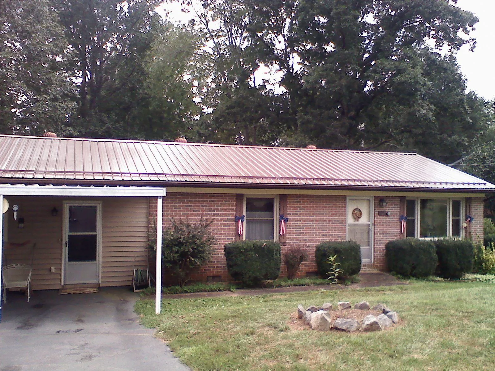 Bronze metal roof and carport on a brick ranch home — Roof Repair work by our crew in Pilot Mountain