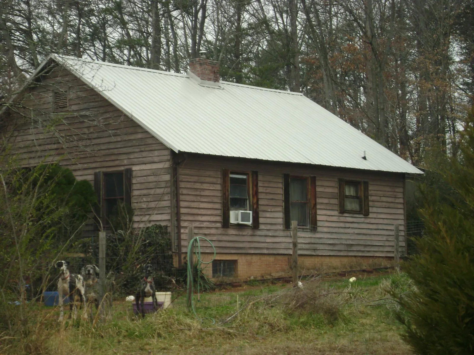 White metal roof on an old wood sided farmhouse, from a Metal Roof Installation job in Pilot Mountain